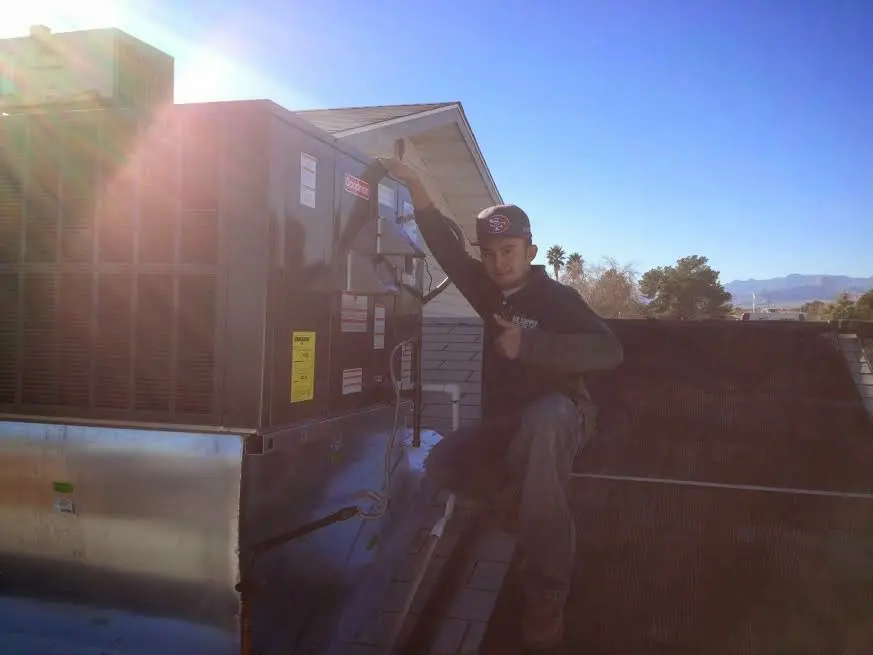 HVAC technician performing Heat Pump Repair on a rooftop unit in Red Hill